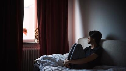 man sitting on sofa and looking through window
