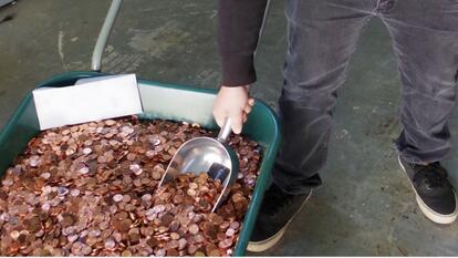 a bucket full of pennies and an envelope sitting on top of it