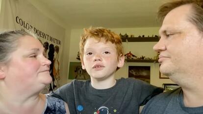 Ray Jordan standing between his parents