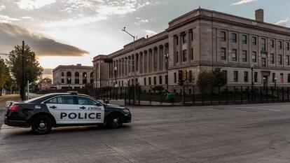 A Kenosha Police car drives past the Kenosha Courthouse surrounded by surrounded by temporary security gates