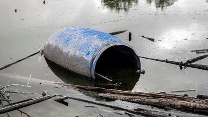 Toxic waste plastic drum on the shore of a reservoir