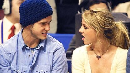 Pop superstars Britney Spears (R) and boyfriend Justin Timberlake (L) talk as they sit courtside at the NBA All-Star Game 10 February 2002 in Philadelphia. 