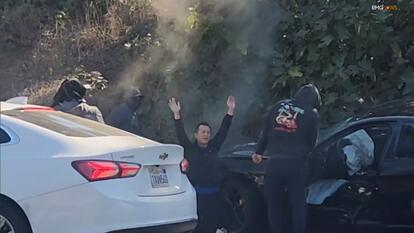 Victim of an intentional car crash and robbery holds his hands in the air