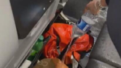 water being poured over orange backpack