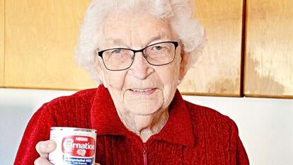 Grandmother holds can of Carnation milk