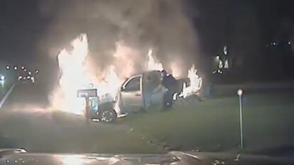 Cop pulling driver from burning car