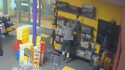 Suspected thief reaching for Lego set on top shelf