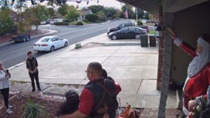 Neighbor takes picture of homeowners posing in front of their new life-size Santa Christmas decoration
