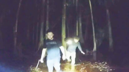2 men walk in swamp