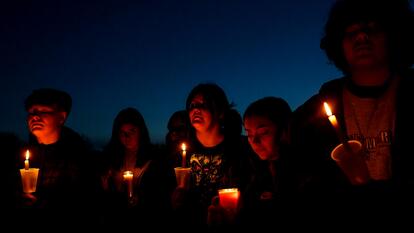  People holding candles at nighttime vigil