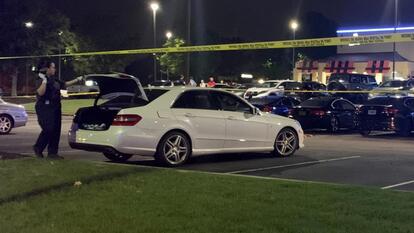 Car with trunk open behind police tape