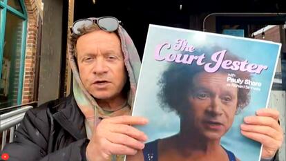 Comedian Pauly Shore holding the poster for his upcoming film The Court Jester