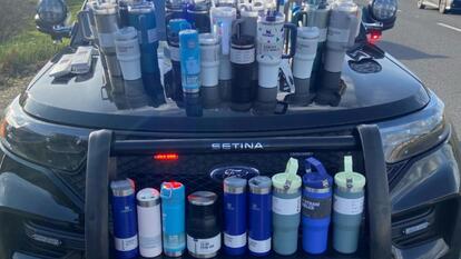 dozens of Stanley tumblers on car and in trunk.