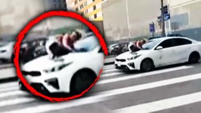 Woman jumps onto moving car 