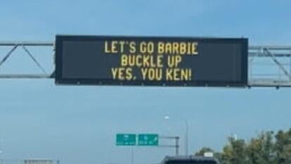 Highway sign reading, "Let's Go Barbie Buckle Up. Yes, You Ken."