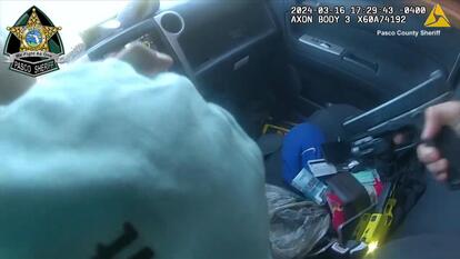 Deputy pointing gun at suspect in car.