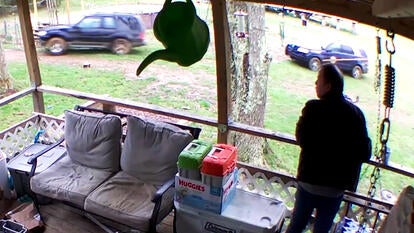 Man watches a car chase from his front porch