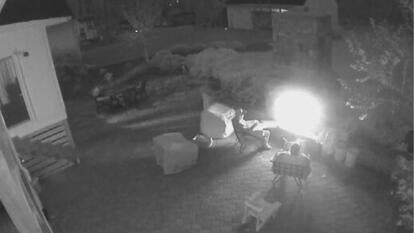 two men sitting by fire pit