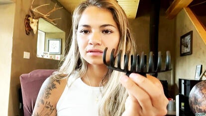 Jogger holds up hair clip that she claims saved her life during a bear attack