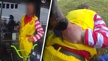 Man in yellow and red clown costume, clown getting handcuffed on the ground