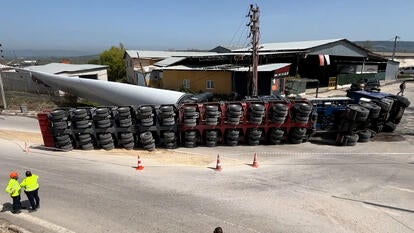 Toppled truck toting turbine blade in Turkey, rescue workers stand nearby