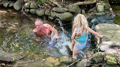 RFK Jr. swimming in a creek with his family