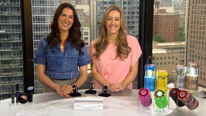 two women standing behind a display of make-up, bracelets, and colorful lanterns