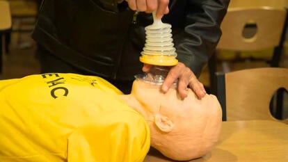 A person using a LifeVac on a CPR dummy