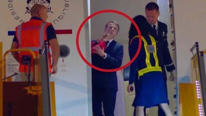 French President Emmanuel Macron with hands on his face as flight crew prepares for the President and his wife to deplane 