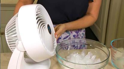 Fan blowing over a glass bowl of ice