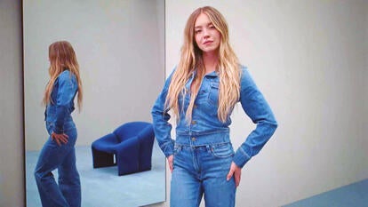 Sydney Sweeny posing in front of a mirror wearing a denim long sleeve button down and denim pants