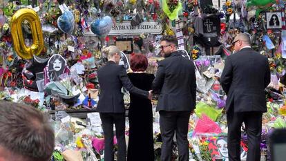 Ozzy Osbourne's widow mourning in front of a large display of memorabilia 