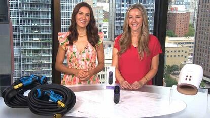 Two women standing behind a table displaying hoses, a video doorbell, and a hand massager