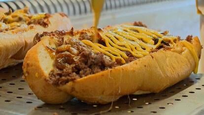 Cheese poured onto steak sandwich