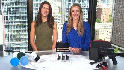 Two women standing behind a table displaying Spin Scrubber, Makeup Set, Jump Starter