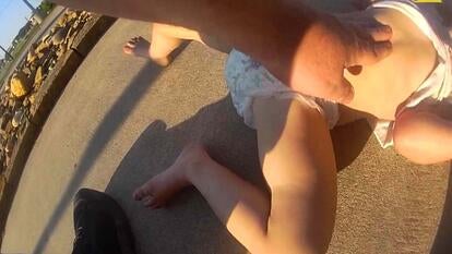 Adult performing the Heimlich maneuver on a young child wearing a diaper