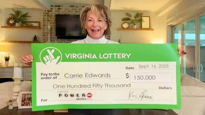 Carrie Edwards holding a large lottery check while smiling