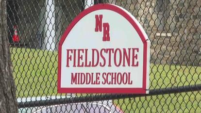 sign for Fieldstone Middle School fixed to a chain link fence 