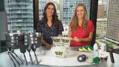Two women behind a table displaying a Cookware Set, Alien Tape, Power Scrubber
