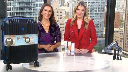 Two women standing behind a table displaying Carry-On Luggage, Prep Set, Handheld Vacuum
