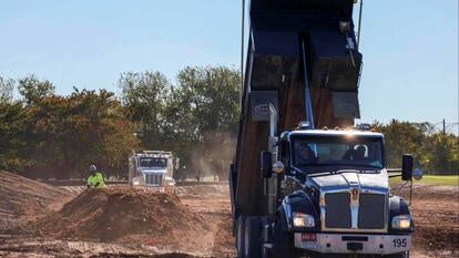 Large construction truck dumping its contents into a pile of dirt