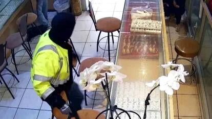 Man in construction reflective jacket standing over a jewelry counter