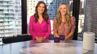 Two women standing behind a table displaying Curling Wand, Earrings, Humidifier & Diffuser