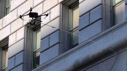 Drone spraying water at a building