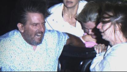 Photo of couple holding onto a girl sitting behind them on a roller coaster