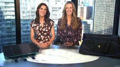 Two women standing behind a table displaying an Indoor Grill, Tire Inflator, Duffel Bag