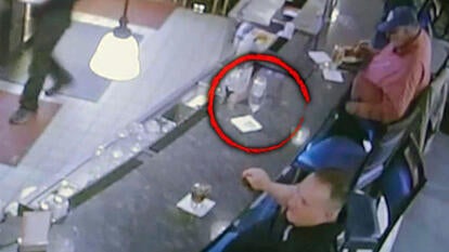 Surveillance footage of a bar with a red circle around a drink