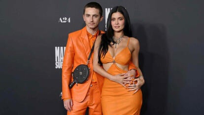 Timothee Chalamet And Kylie Jenner in orange posing on the red carpet