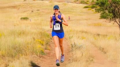 Woman wearing running gear while running through a field