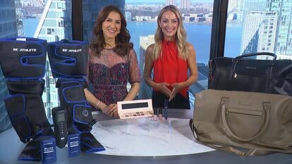 Two women standing behind a table displaying a Massager, Makeup Set, Compression Tank Tops Or Shorts